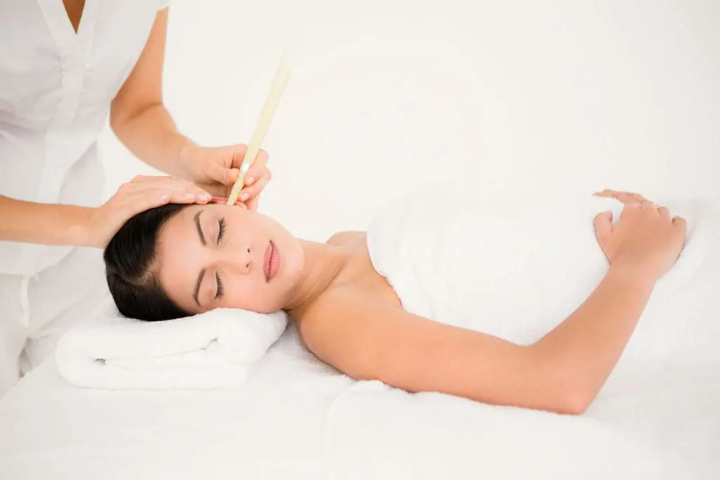 Female with ear candle being applied
